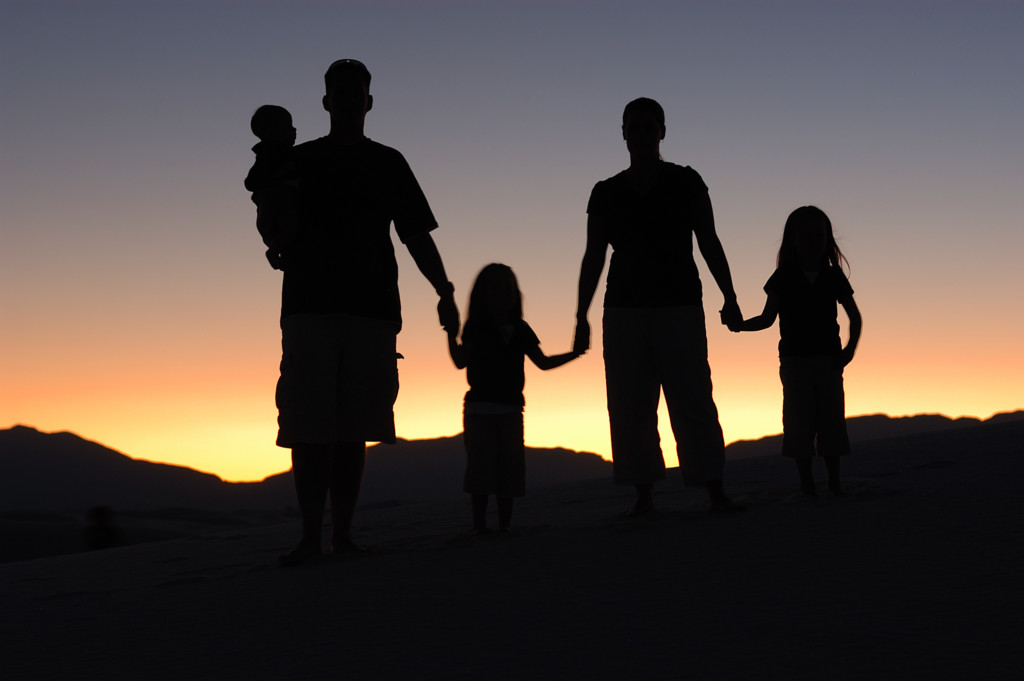 silhouette of a family holding hands in the sunset