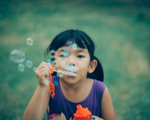small child blowing bubbles