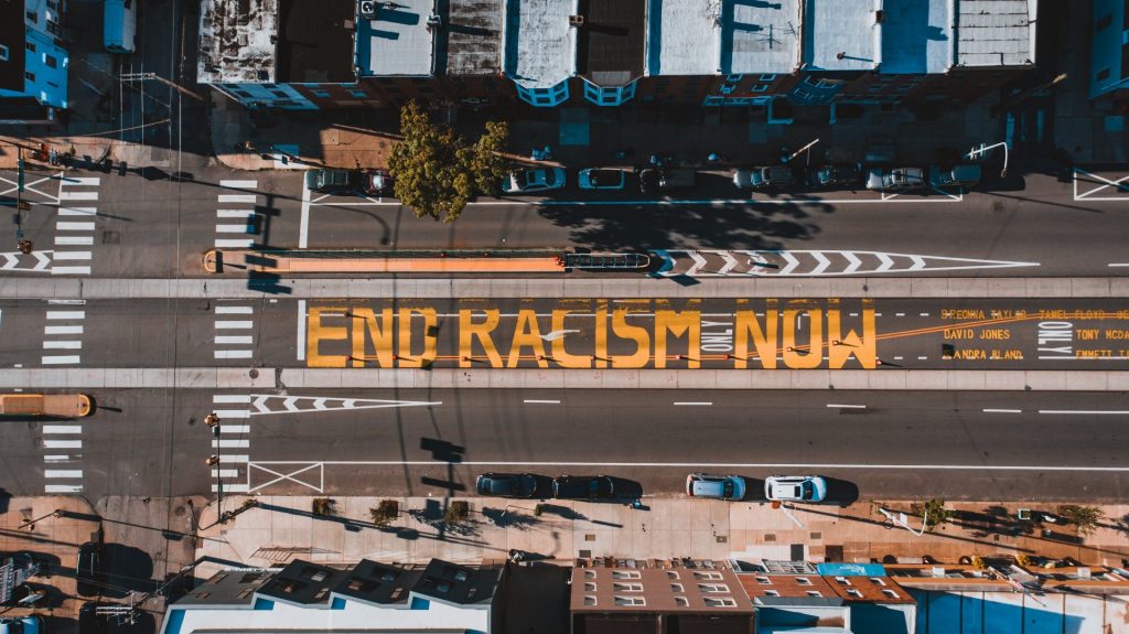 a view from above of a DC street with words painted on it: "end racism now."