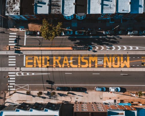 a view from above of a DC street with words painted on it: "end racism now."