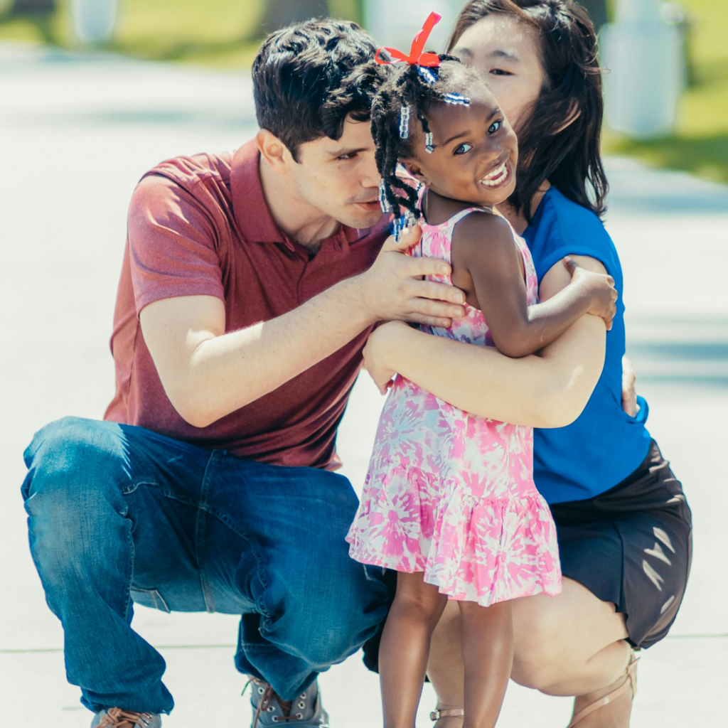 young family embraces daughter